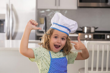 Funny kid chef cook cookery at kitchen. Chef kid boy making healthy food. Portrait of little child...
