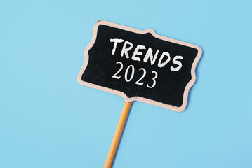 TRENDS 2023 - text on a small chalkboard on a blue background. Top view. Business management, Inspiration to success ideas