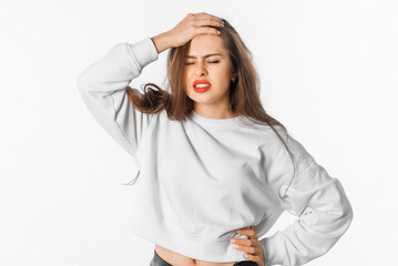 Unhappy frustrated woman frowns face, touches head, shows white teeth, expresses negative feelings....