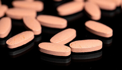 Close up of Multi Vitamin tablet on a reflective black backgroun