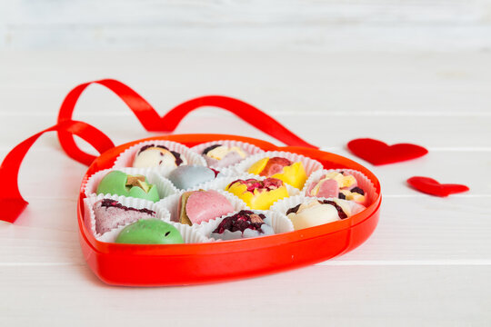 Valentine day composition: sweet candy, with gift boxes with bow and red felt hearts, photo template, background. Perspective View with copy space