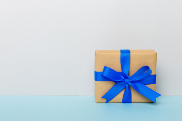 holiday handmade paper present tied blue ribbon bow top view with copy space. Flat lay holiday background. Birthday or christmas present. Christmas gift box concept with copy space
