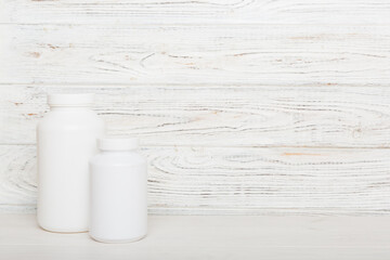 supplement pills with medicine bottle health care and medical top view. Vitamin tablets. Top view mockup bottle for pills and vitamins with green leaves, natural organic bio supplement, copy space