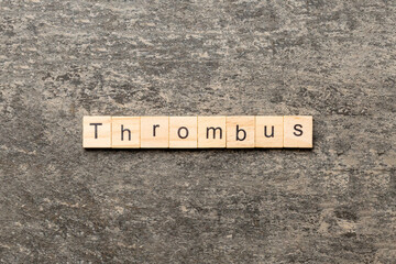 thrombus word written on wood block. thrombus text on table, concept