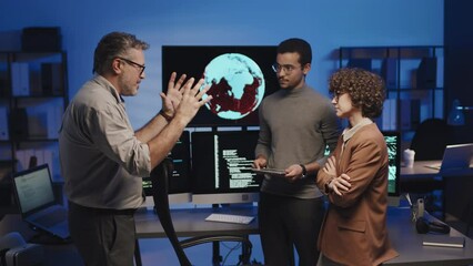 Medium shot of mature manager giving task to programmers about development of new security software - Powered by Adobe