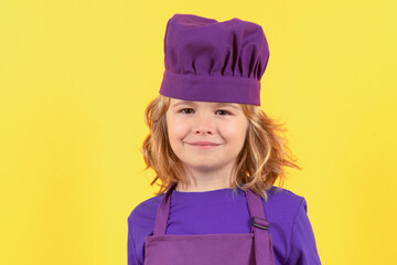 Funny kid chef cook studio portrait. Excited chef cook. Child wearing cooker uniform and chef hat preparing food, studio portrait.