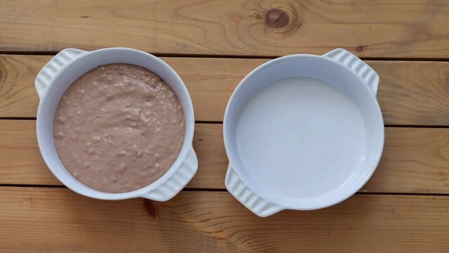 The process of making a homemade birthday cake with cream, nuts and and lit candles. Ingredients for dough, decoration with dried fruits and nuts. Stop motion, top view, flat lay