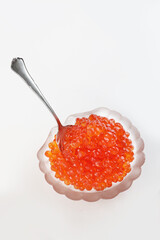 Red caviar. The caviar is in a shell-shaped dish. White background. A useful omega. An appetizer on holiday. An expensive treat. Caviar of sturgeon and salmon fish.