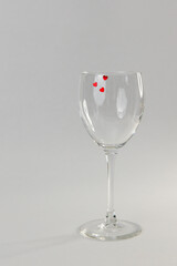 transparent wine glass on a light background with three hearts