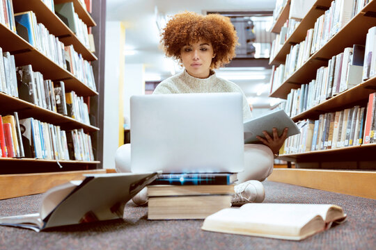 College Library Learning, Laptop And Black Woman Student Working On The Floor With Books. Reading, Computer Research And Online Study Of A Person With Test And Exam Information For University