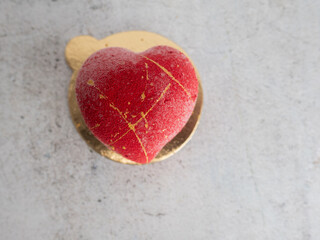 Fototapeta na wymiar Bright red soft, chewy, red velvet sprayed flavour heart shaped sweet cake for Valentine's Day
