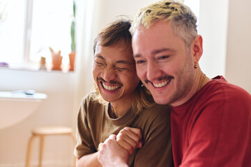Close Up Of Loving Same Sex Male Couple At Home Laughing And Cuddling Together