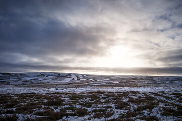 Fototapeta na wymiar The frozen snow covered hills, countryside at sunrise of Muggleswick and Edmondbyers common, moor in winter near Blanchland, Northumberland in England UK.
