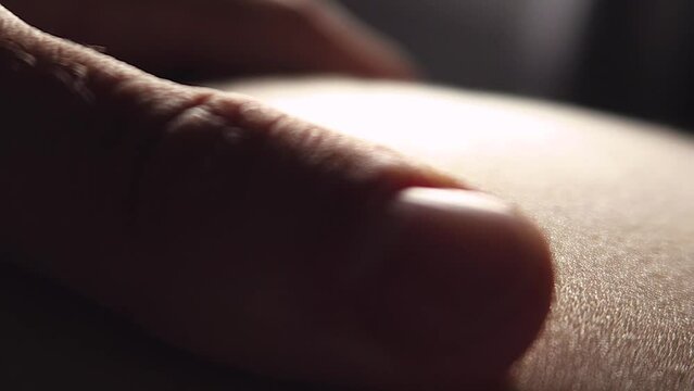 Intimate close-up of a hand stroking a woman's body.