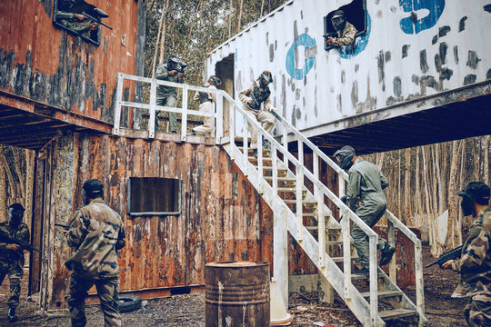 Paintball, steps or men in a container or shooting game playing with speed, fast or fun action. Mission focus, military or people running in battle with guns for survival in an outdoor competition