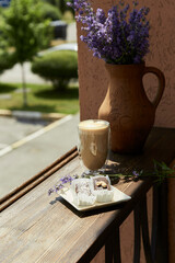 Natural, sugar free cocoa dessert with a glass of latte and lavender flowers outside in the cafe...