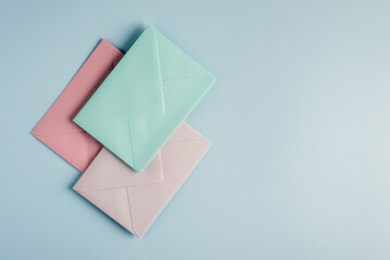 Collection of envelopes in pastel colors on a light blue background.