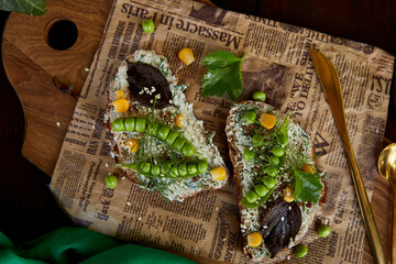 Homemade rustic natural healthy sandwich with peas, basil and corn on greased cheese. Healthy snacks with cutlery. Ogranic natural summer food