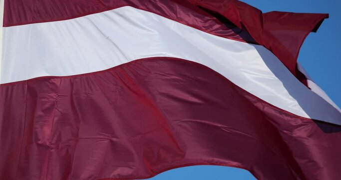 The national latvian flag waving in the wind.