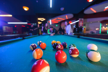 Excitement fills the room as players aim for victory in a game of billiards on a classic pool table. Precision and strategy required