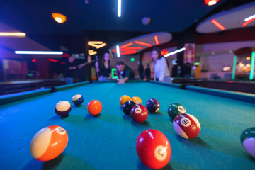 Billiards enthusiasts face off in a high-stakes game, with focus and determination on their faces,...
