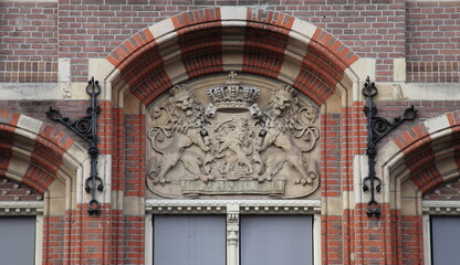 Fototapeta premium Amsterdam Historic Bushuis Building Facade Detail with Sculpted Dutch Coat of Arms, Netherlands