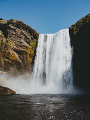 A powerful waterfall cascades down in Iceland, creating a misty veil as it rushes towards the earth