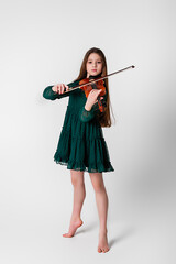 A girl in a green dress plays the violin on a white background.