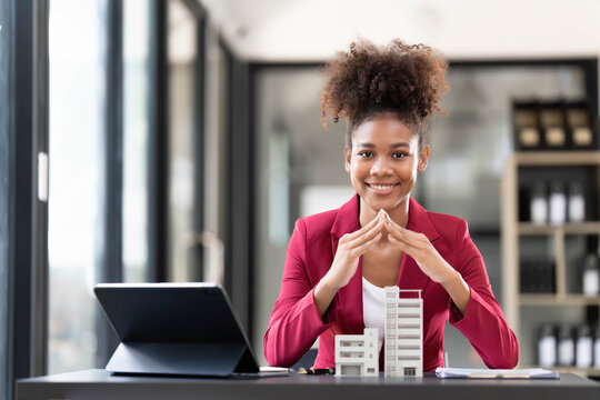 Asian businesswoman making a deal to buy a house or condo inside the office, home insurance concept