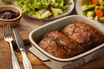 Roasted duck breasts served with vegetables and cranberry dip.