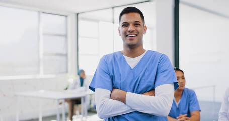 Face, healthcare and insurance with a nurse man standing arms crossed in a hospital for medical...