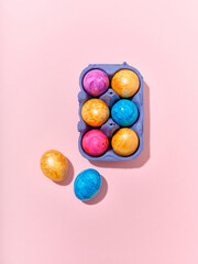 Fototapeta na wymiar Top view layout with colored easter eggs on pink background. Creative template for festive content