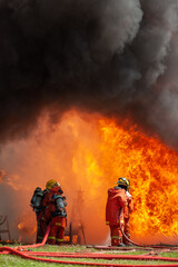 Obraz premium firefighter training new fireman team stop Fire from oil plant blast explode. Fire fighter sprinkle water stop fire burn emergency case at gas station. rescue Care System of Insurance team.