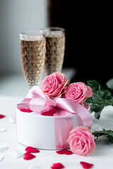 Beautiful surprise greeting for saint Valentine's or Women's Day, birthday or Anniversary for beloved. Fresh pink roses, gift box with sweets. White background. Holiday atmosphere