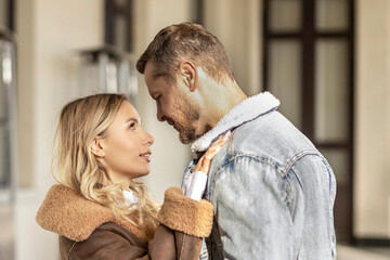 A smiling couple is in love outdoors.A young happy couple embraces on a city street.