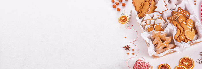 Top view of unpacked christmas present with sweets on a white textured surface, banner, close-up. Christmas celebration concept with space for text