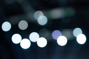 bokeh lights. blurred night white blue gray abstract texture glowing neon light on black background. new year and christmas party concept