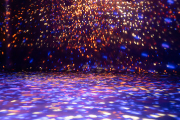 blurred rays of light on disco floor. orange violet blue neon searchlight lights. laser lines and lighting effect. night empty stage in studio with neon reflections. scene dark abstract background
