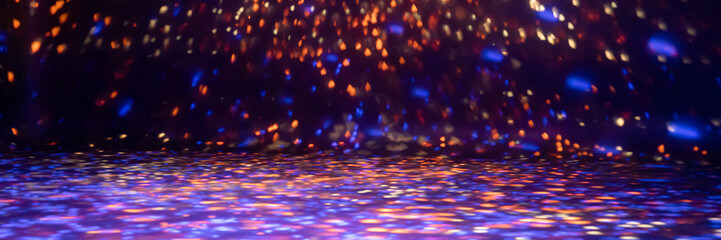 blurred rays of light on disco floor. orange violet blue neon searchlight lights. laser lines and lighting effect. night empty stage in studio with neon reflections. dark abstract background. banner