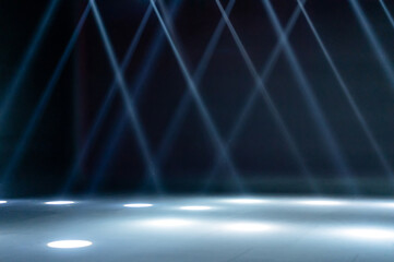 blurred rays of light on disco floor. white blue neon searchlight lights. laser lines and lighting effect. night empty stage in studio with neon reflections. scene of dark abstract space background