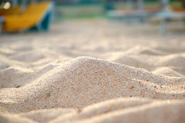 Close up of clean yellow sand surface covering seaside beach illuminated with day light. Travel and vacations concept