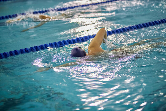 swimmer in the pool, soft focus. swimming in the wave pool, water splashes, bokeh, blur, soft focus. Professional swimmer, race swimming, indoor pool. Sports and fitness cardio exercises.