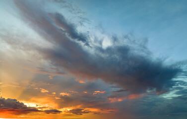 Cumulonimbus clouds forming before thunderstorm on evening sky. Changing stormy cloudscape weather at sunset