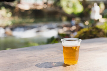 Isolated of beer in plastic glasse on wooden table.