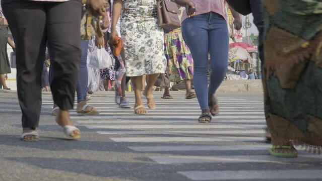 Ghana, February 2023 People walk across the road at Zebra markings.