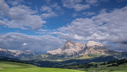 Fototapeta premium View of Sassolungo and Sassopiatto mountains on a cloudy afternoon as seen from Alp di Siusi high mountain plateau , Seiser Alm, Dolomites, Trentino, Alto Adige, Italy