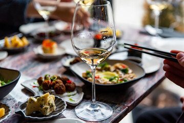 glass with wine and wine snack set, cheese, meat, vegetables and other appetizers on table