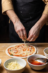 Obraz na płótnie Canvas the chef prepares delicious pizza in the restaurant. Close-up 