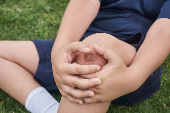 Boy sitting on grass after injury