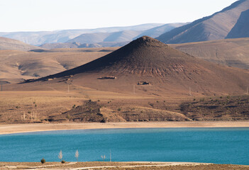 view of the mountains and the blue waters of the tislit lake in Imilchil (Morocco) on a clear day